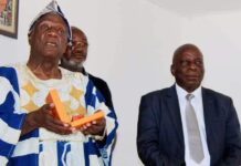 Après sa distinction, le Ministre, Gouverneur présente son titre au Gloudeuh Dan 1er